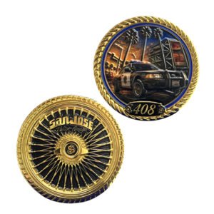 Gold-tone police challenge coin showing a patrol car scene on one side and a black and gold wheel design on the other.