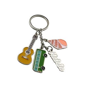 Tropical souvenir keychain with a golden-brown guitar, green bus, pink shell and script lettering charms attached to a metal chain.